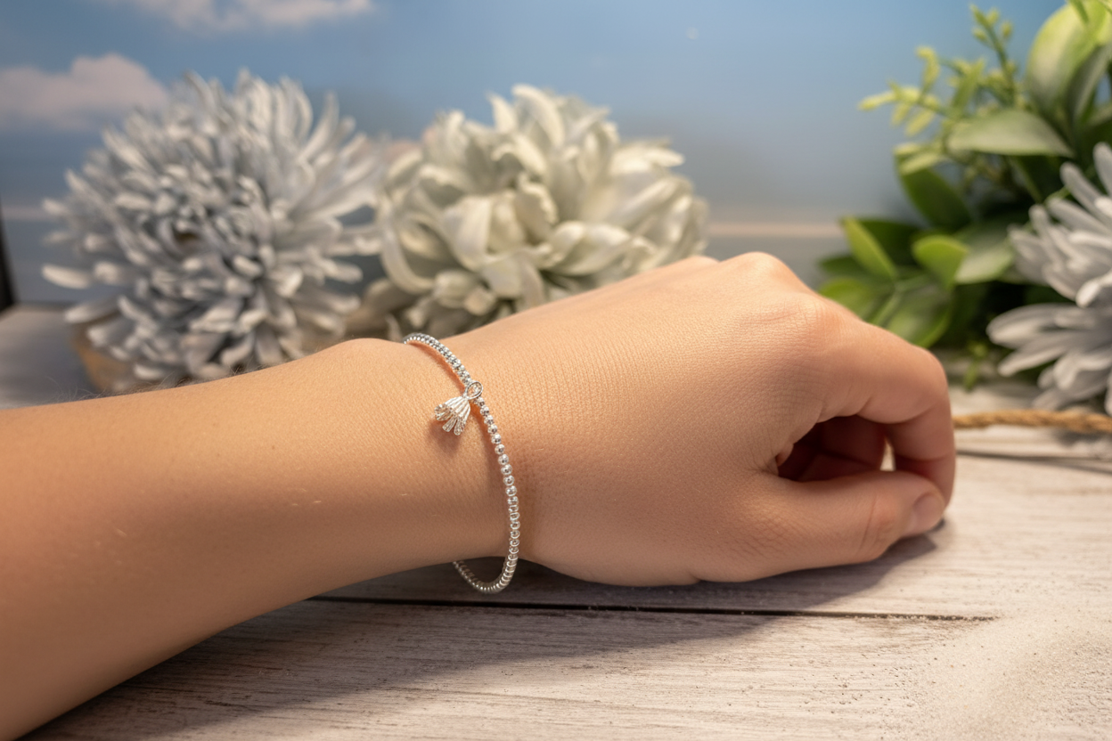 Sterling silver beaded bracelet with dandelion flower charm in natural pose