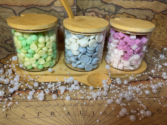 A set of 3 glass wax scoopie jars .