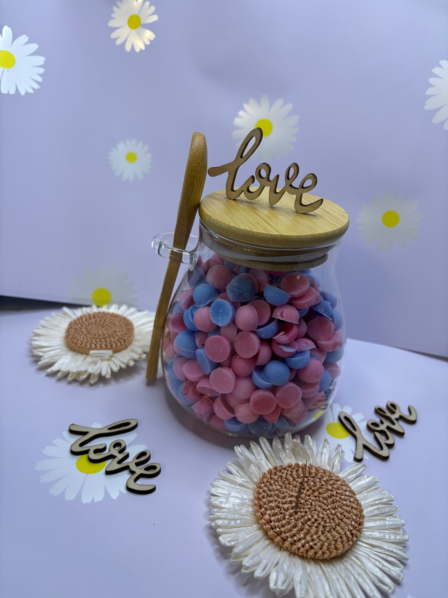 Glass jar filled with scented wax scoopies.