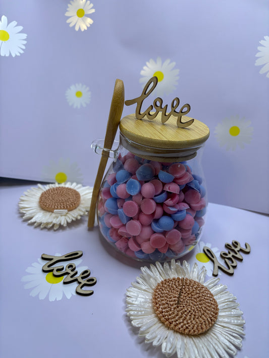 Glass jar filled with scented wax scoopies.