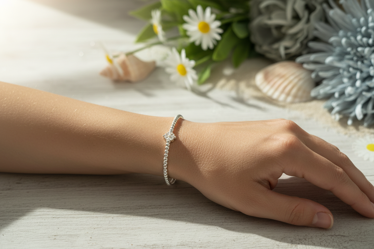 Sterling silver beaded bracelet with flower bead charm on lady's arm